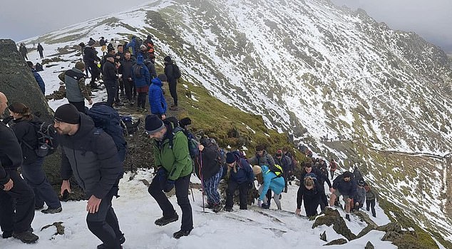 Largas colas de excursionistas en el pico más alto de Gales Snowdon