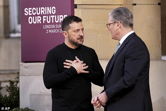 El primer ministro de Gran Bretaña, Keir Starmer, a la derecha, habla con el presidente de Ucrania, Volodymyr Zelenskyy, cuando llega a una cumbre en Ucrania en Lancaster House en Londres, el domingo 2 de marzo de 2025. (AP Photo/Christophe Ena, Pool)