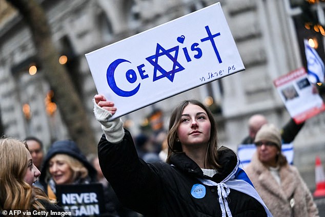 Un manifestante tiene la lectura de 'coexist' durante una manifestación en el centro de Londres, el 26 de noviembre de 2023, para protestar contra el antisemitismo