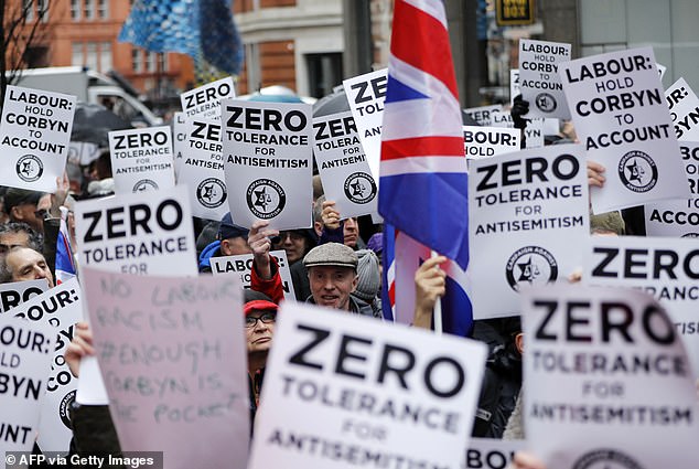 Las personas sostienen pancartas y banderas sindicales mientras se reúnen para una demostración organizada por la campaña contra el antisemitismo en Londres en abril de 2018