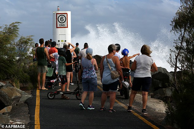 La gente observa como un gran y creciente oleaje en el sureste de Queensland alrededor de Point Cartwright en Sunshine Coast, Queensland, domingo 2 de marzo de 2025