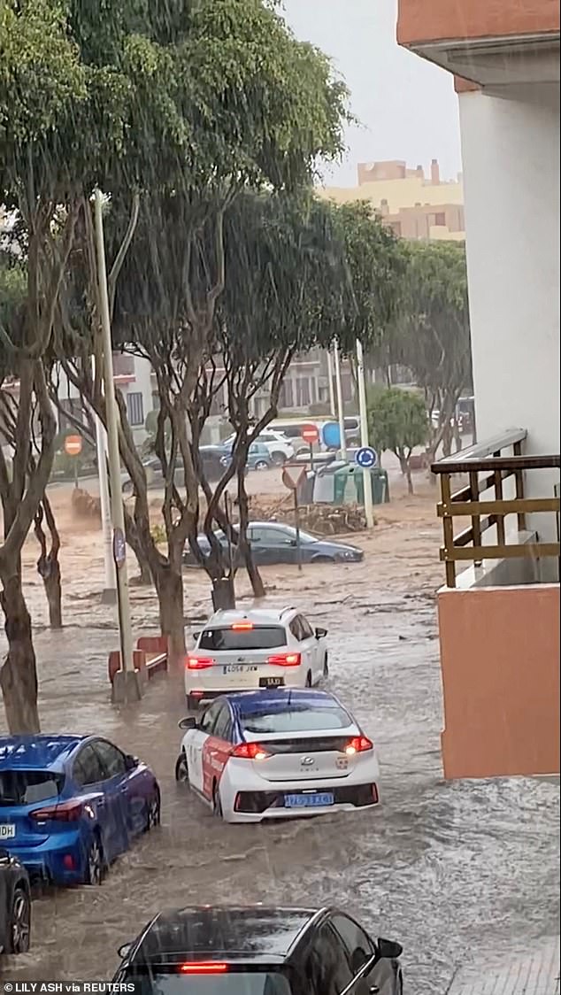 Un automóvil parcialmente sumergido permanece atascado después de las inundaciones repentinas en Telde