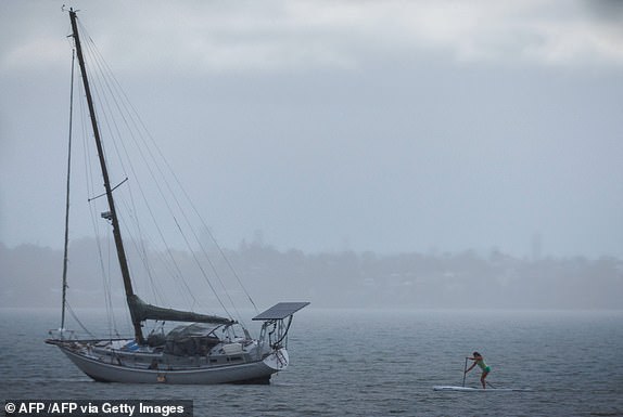 TOPSHOT - Una mujer más allá de un yate en Wellington Point en Brisbane el 5 de marzo de 2025. El ciclón tropical Alfred se desvió hacia la costa oriental densamente poblada de Australia el 5 de marzo, generando advertencias de emergencia, cerrando cientos de escuelas y amenazando con inundar miles de hogares. (Foto de Patrick Hamilton /AFP) (Foto de Patrick Hamilton /AFP /AFP a través de Getty Images)