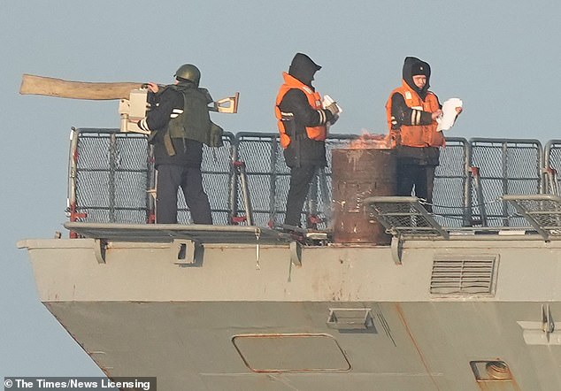 Los oficiales armados en las chaquetas de flak se encuentran a bordo del buque de guerra ruso el lunes