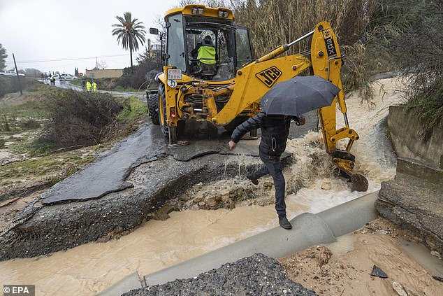 Un trabajador usa una excavadora en una carretera dañada cerca del río Quipar en la ciudad de Cehegin debido a fuertes lluvias en Murcia, el sureste de España el jueves