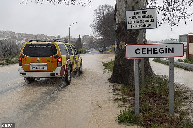 Un vehículo de servicios de emergencia se conduce a través de una carretera inundada en la ciudad de Cehegin en medio de fuertes lluvias en Murcia, el sureste de España el jueves