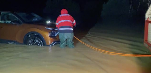 Se vio a los bomberos vadeando a través del agua hasta la rodilla mientras intentaban despejar las carreteras