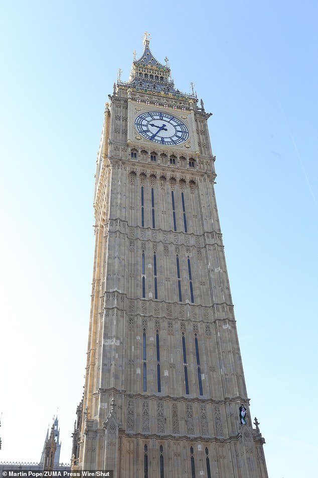 El manifestante se muestra en el lado de Big Ben hoy después de escalar la estructura histórica