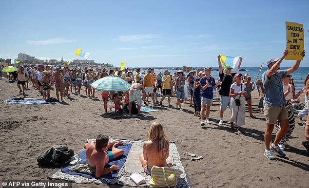 Los manifestantes marchan en Las Americas Beach durante una manifestación para protestar contra el turismo de masas, en Arona en la isla canaria española de Tenerife, el 20 de octubre de 2024