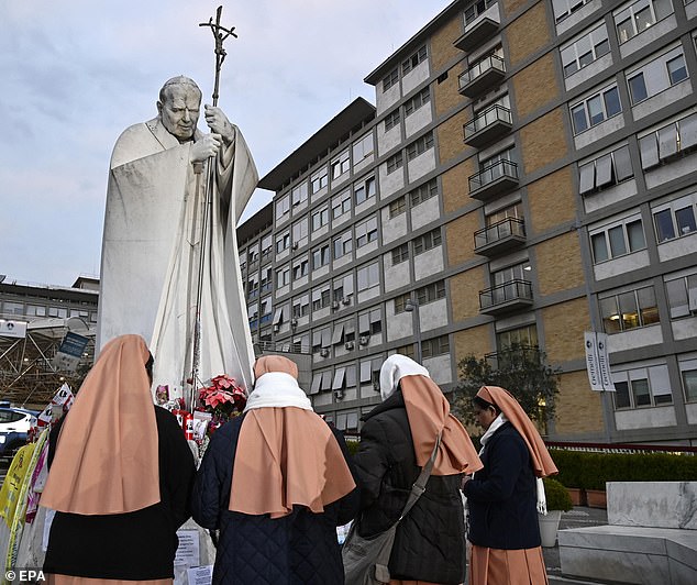 Monjas rezan frente a una estatua de Juan Pablo II en la entrada del Hospital Gemelli donde el Papa Francisco todavía está hospitalizado